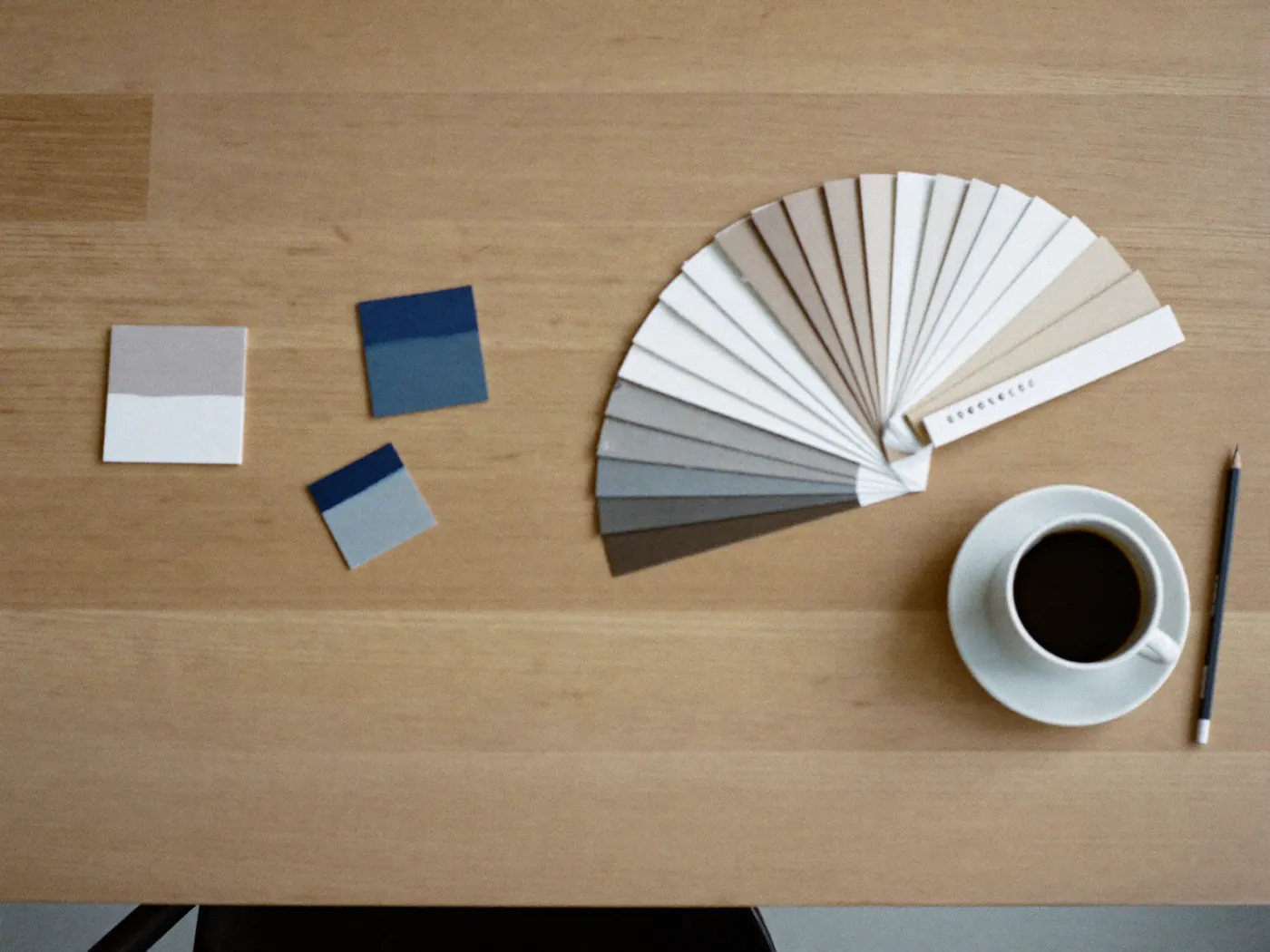 Kleurwaaier en drie proefplankjes op een eiken tafel